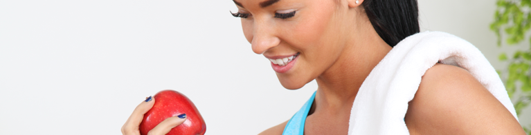 Woman in work out clothes about to eat an apple