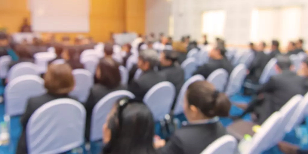  Imagen de archivo de personas sentadas en una reunión comunitaria o presentación de una conferencia