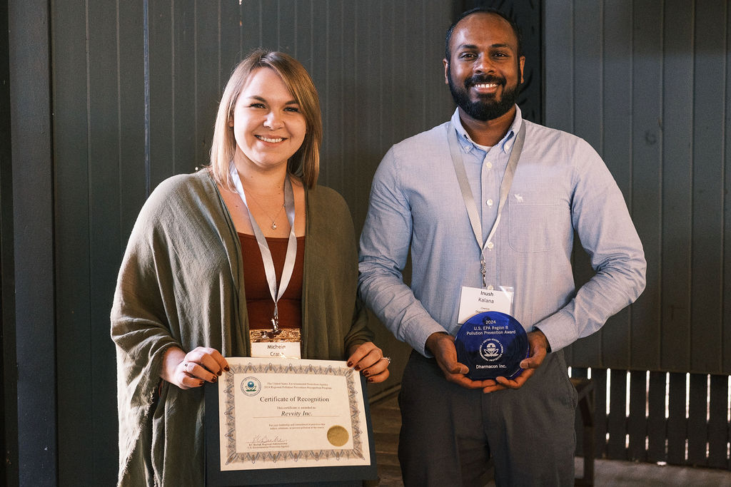 A lady and a man from Revvity Inc. holding the 2024 EPA pollution prevention award trophy and certificate