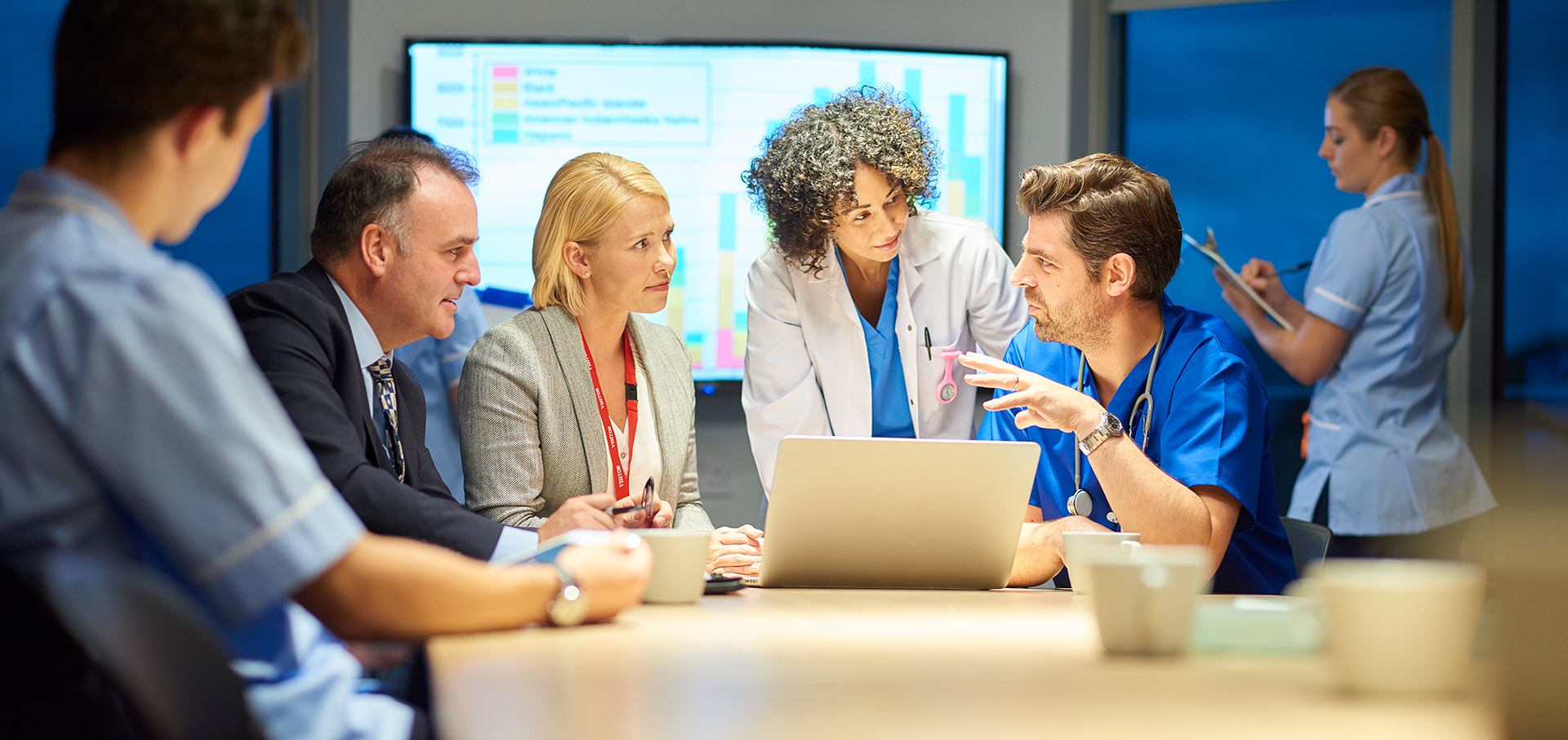medical professionals gathered around a large table in conversation