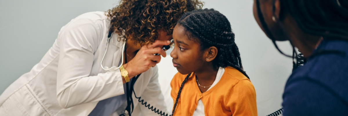 Black girl gets check up at doctor's office