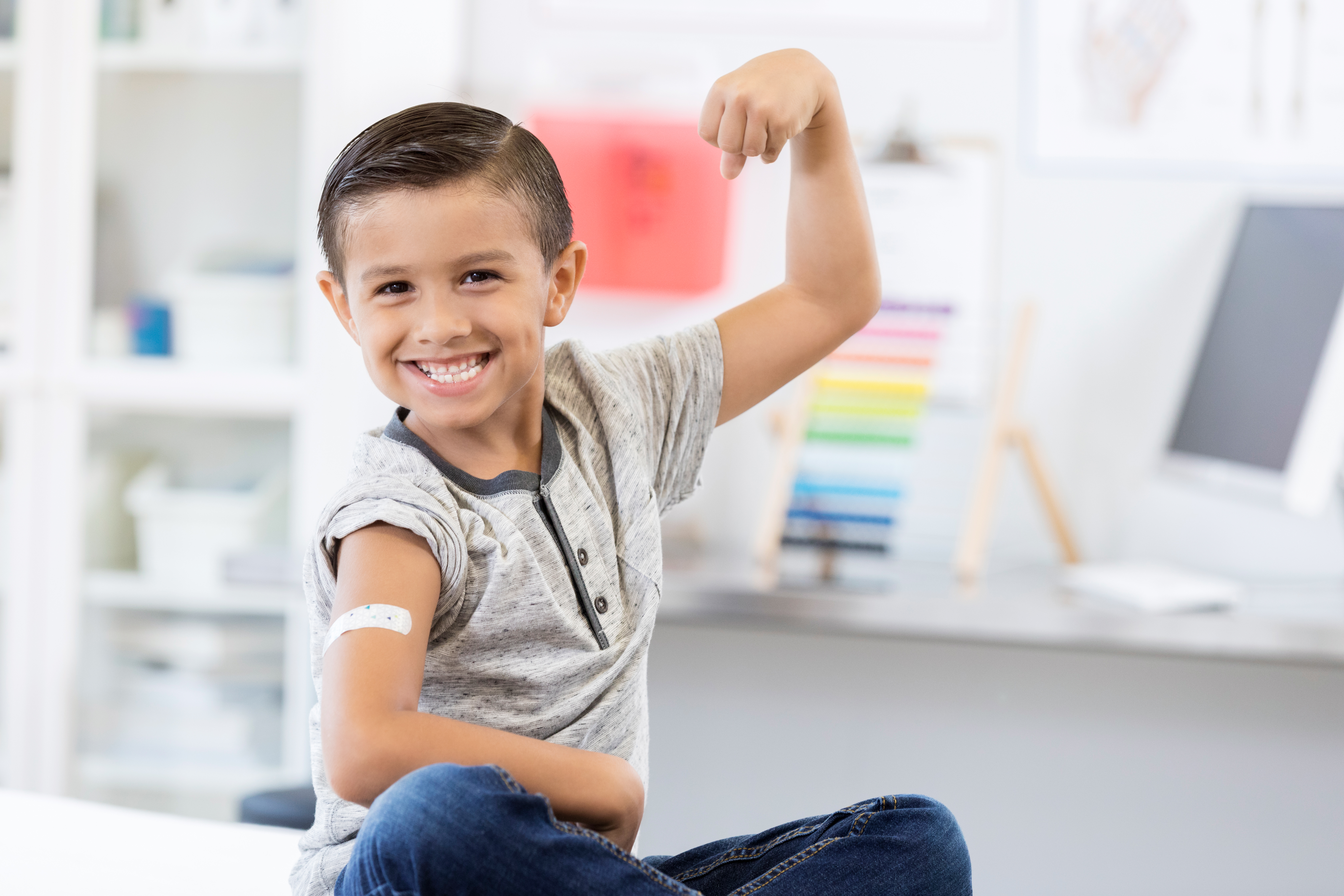 smiling boy showing off his bandaid