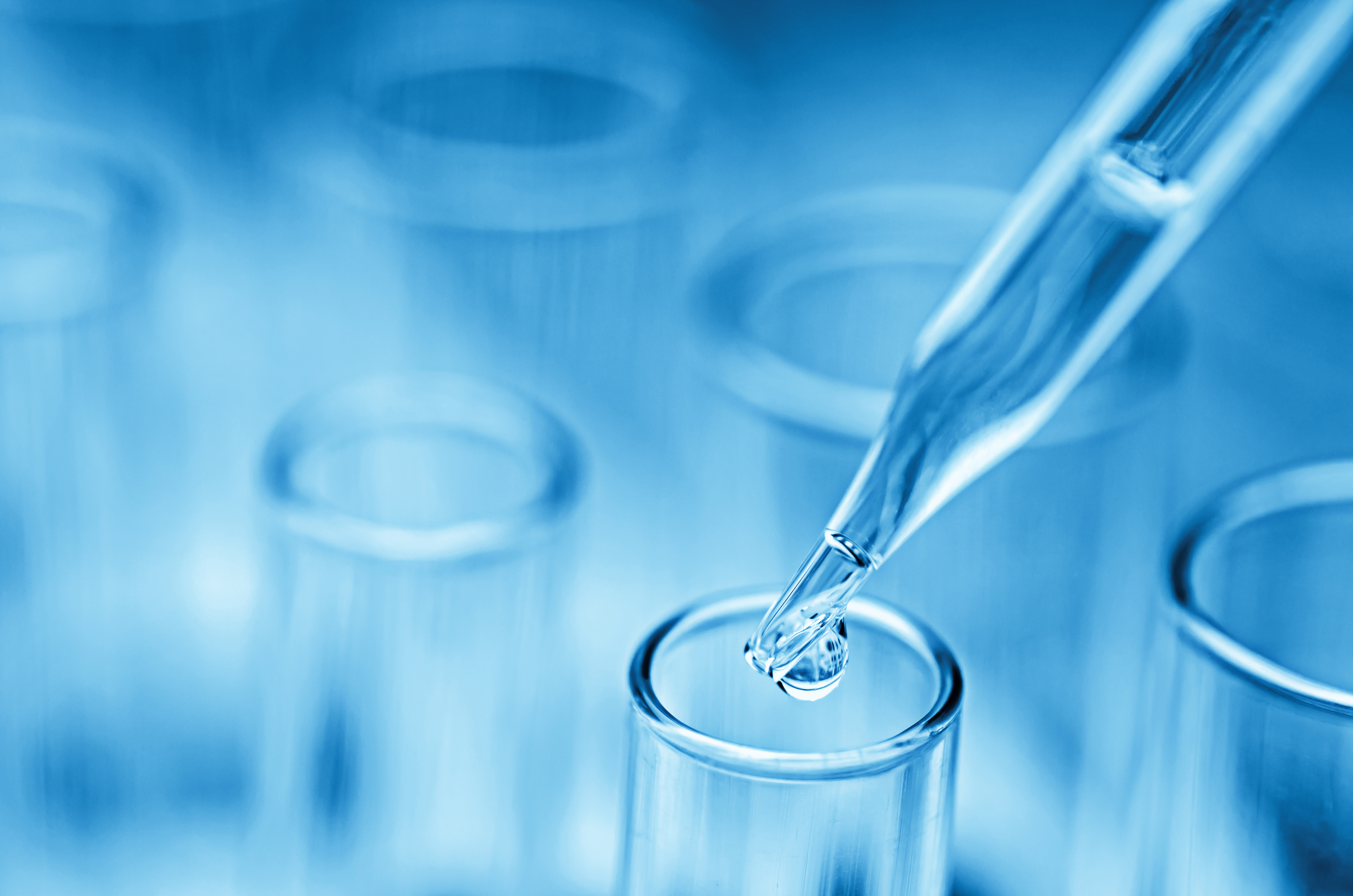 Blue test tubes with one dropper adding liquid to one of the test tubes.