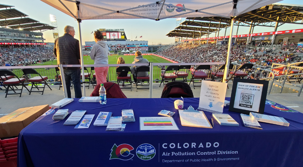 Air Pollution Control Division tabling event at Rockies game with game in background
