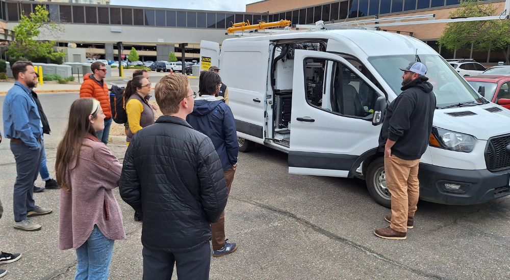 People standing outside looking at the air division mobile monitoring equipment van.