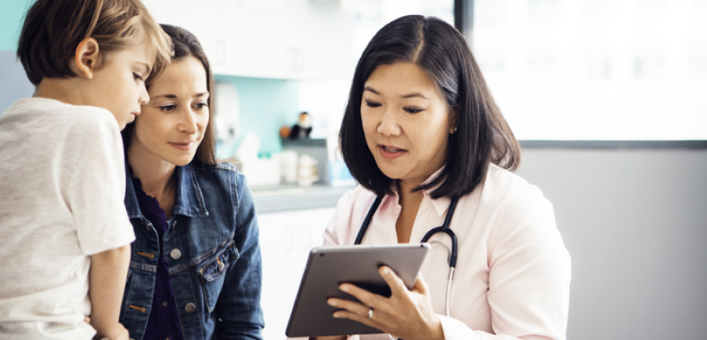 Un pediatra se reúne con un niño pequeño y la madre del niño.