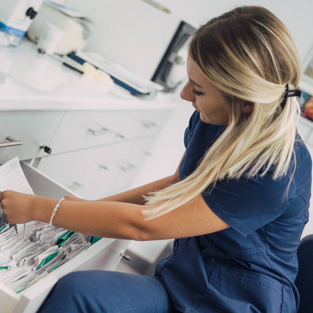 health care pro looking through files in a cabinet