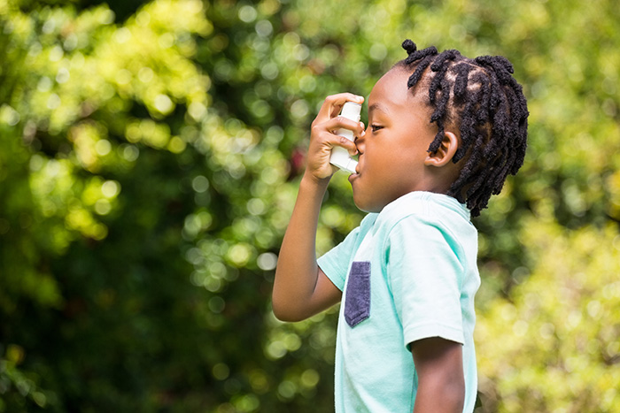 young child using an asthma inhaler