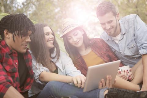 young people gathered around a tablet