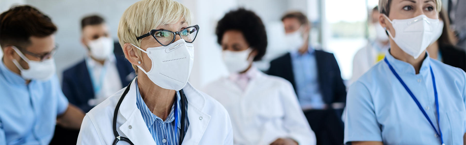 Healthcare professionals sit in a class wearing masks