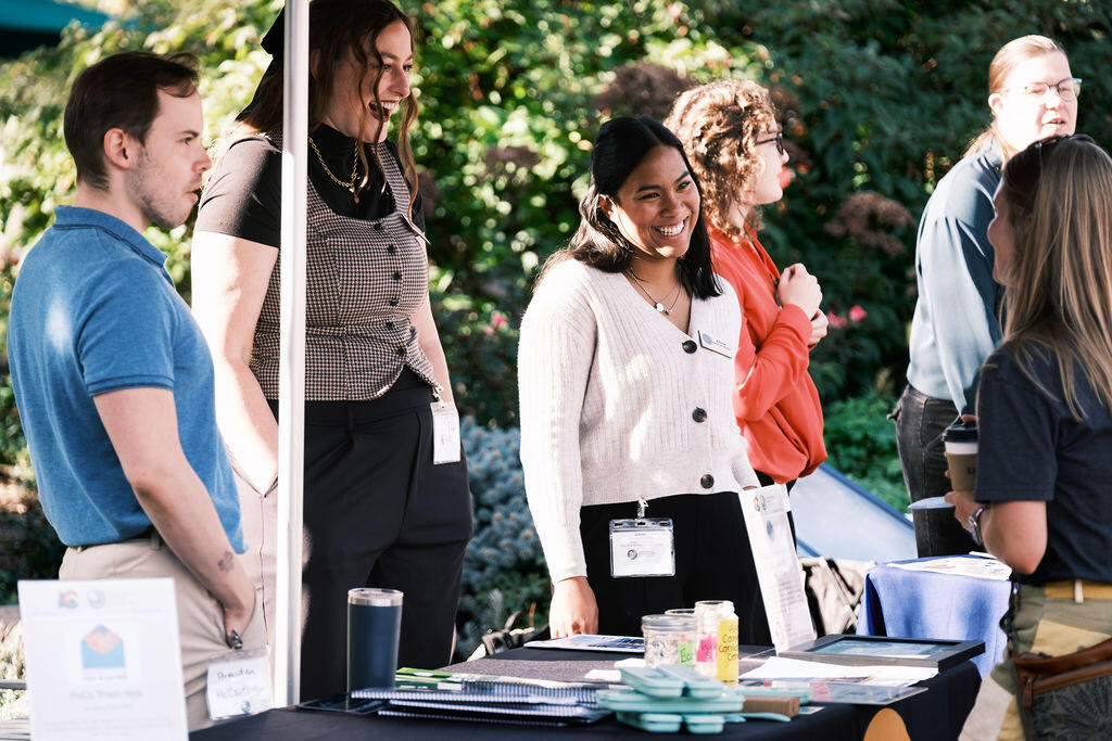 Staff from Lotus Engineering and Sustainability standing behind a table laugh in enjoyment