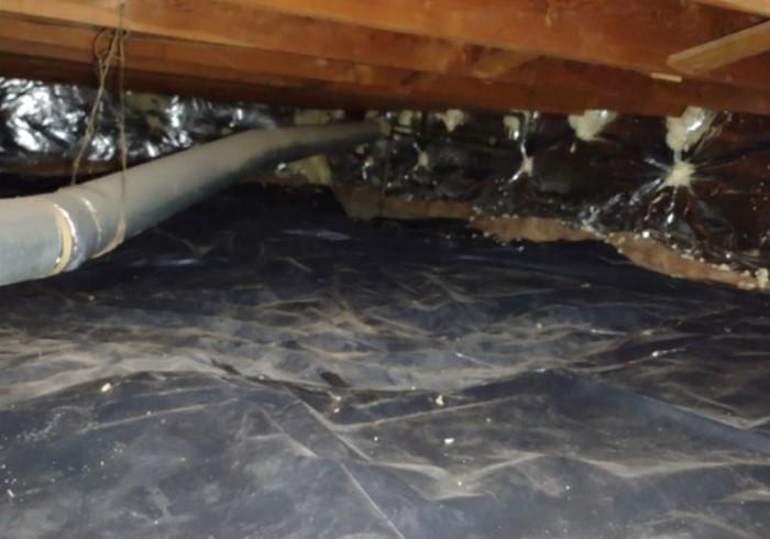 Crawl space of a house with HVAC ducts, cleaned and lined