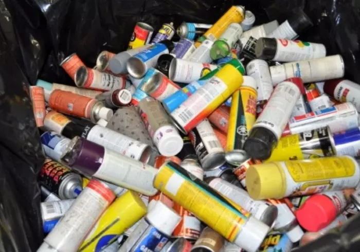 Spray paint cans in a bin, for recycling