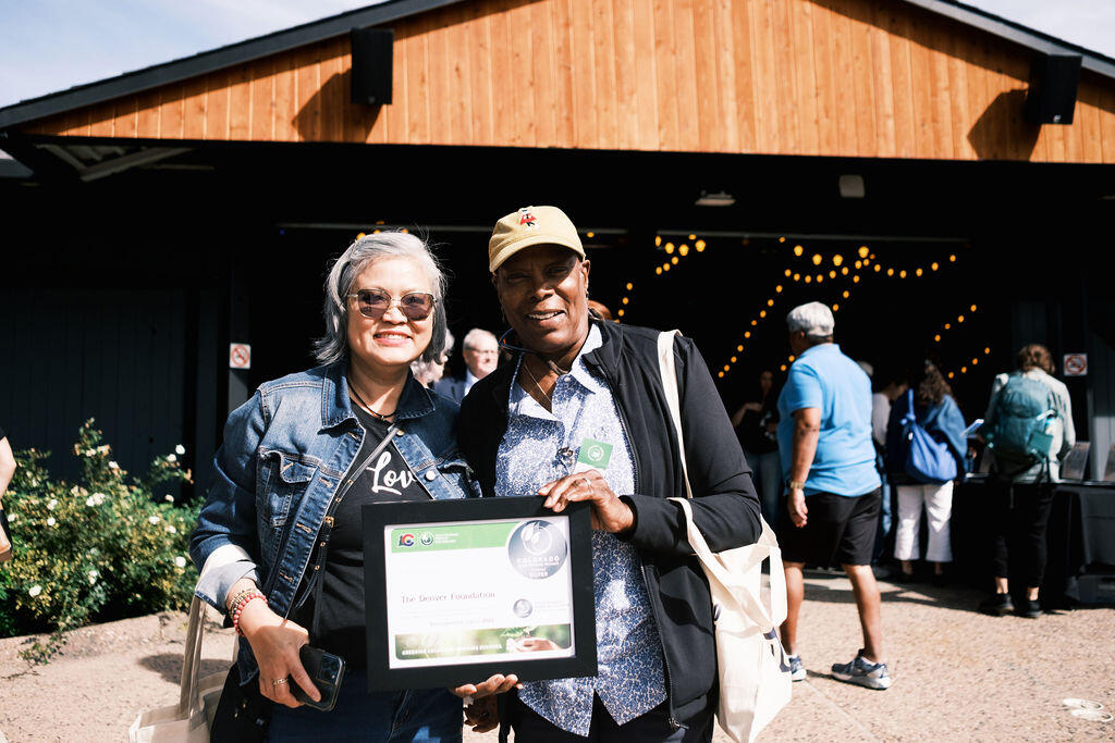 A man and a woman pose for a picture while holding their silver certificate together