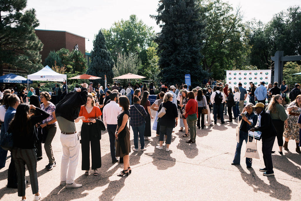 A large group of people mingle at the Denver Zoo