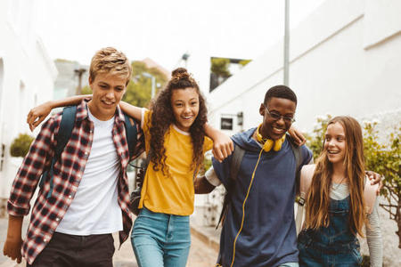 smiling teens walking arm-in-arm