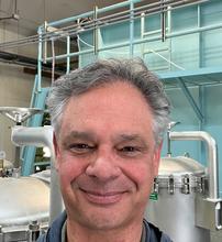 Robert Ludwig standing in front of an indoor water tank smiling