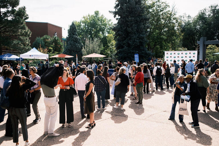 A large group of people mingle at the Denver Zoo