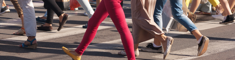 Legs and feet of people in a crosswalk