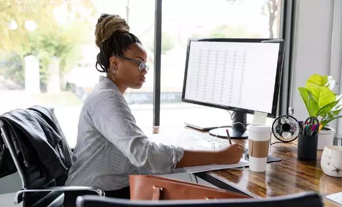 A mid adult African American businesswoman concentrates while working in her office.