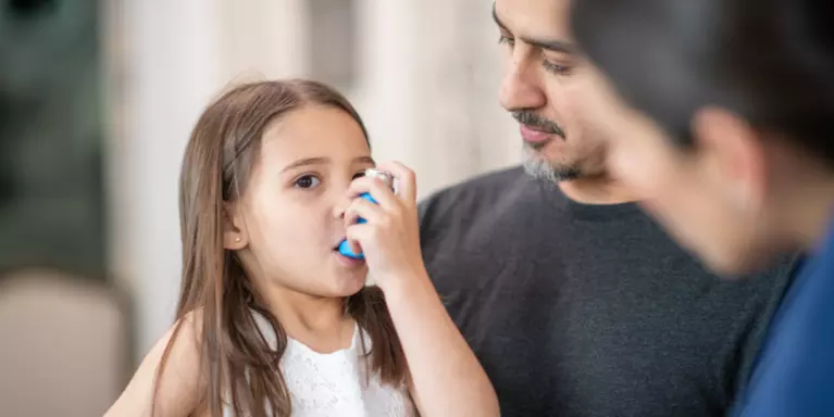 Preschool age girl with asthma learns to use an inhaler