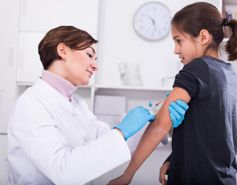doctor giving girl vaccine