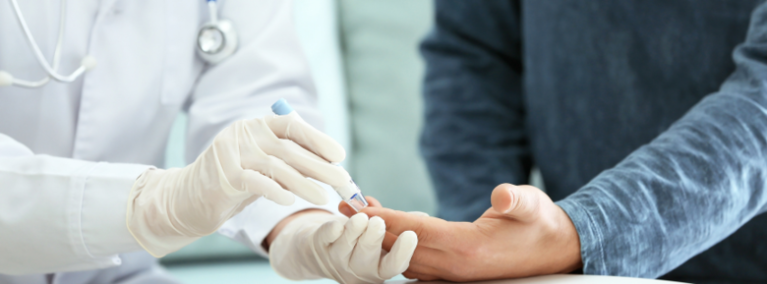 Health care provider performing finger prick on patient